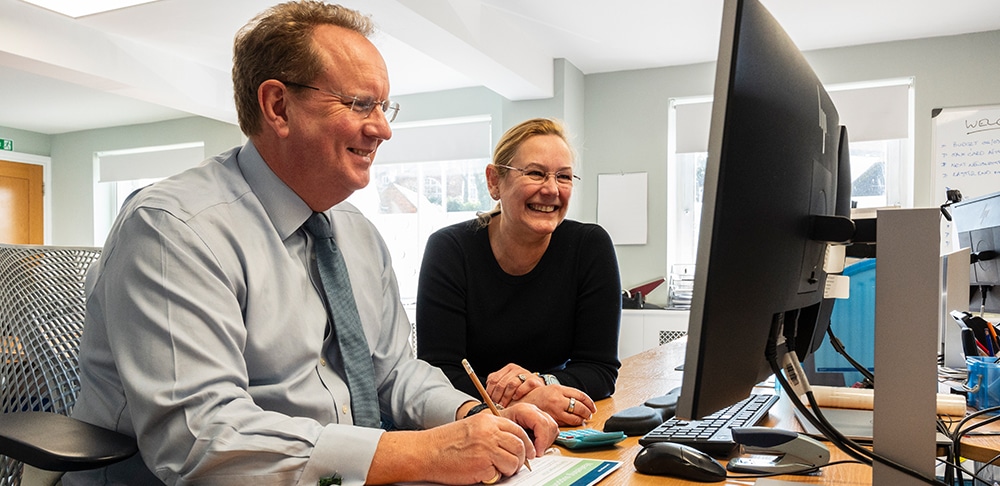 Two people at Chapters Financial looking at a computer screen and smiling