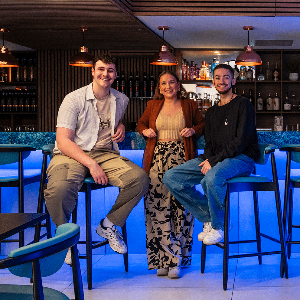 Three members of staff at the bar in a restaurant