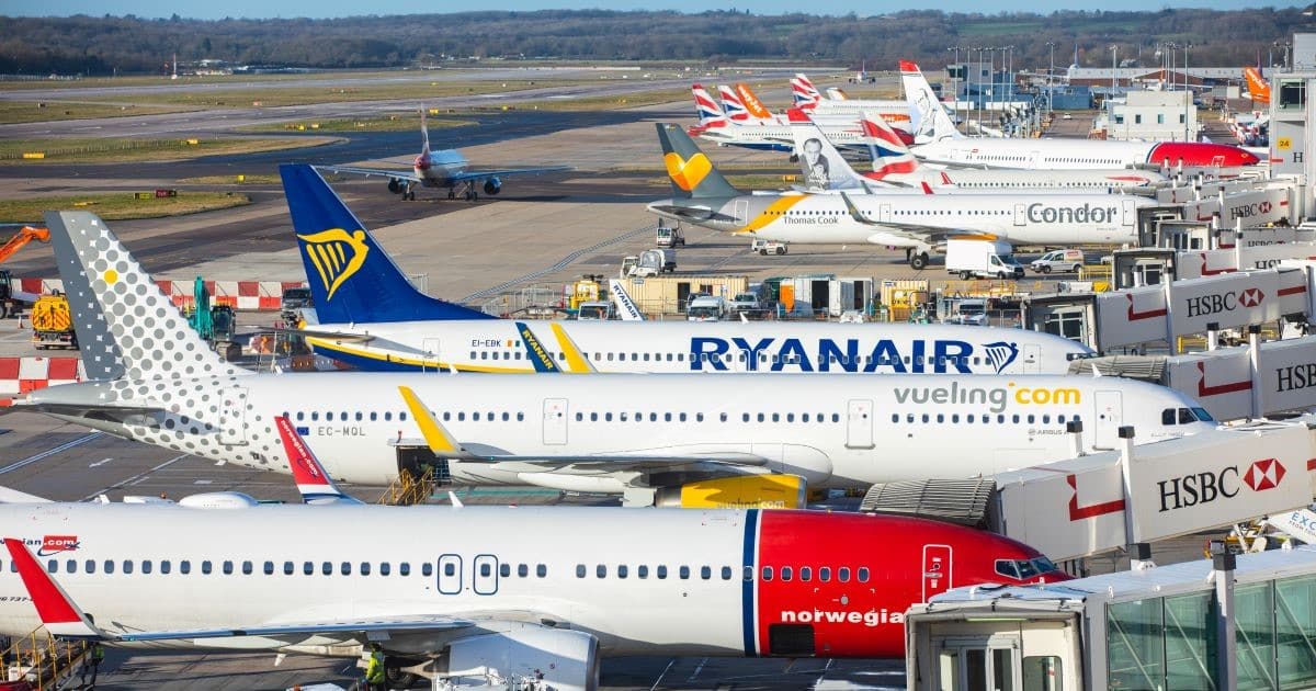 A series of planes line up at passenger docking ports at Gatwick Airport.