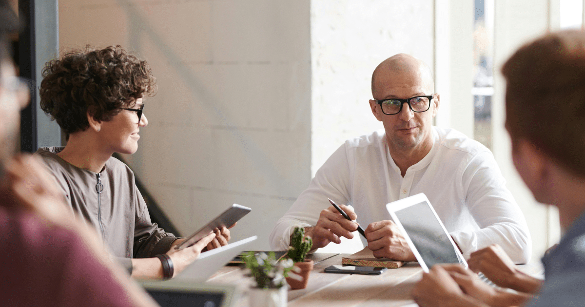 Business continuity - image of business team sitting around a table, in discussions