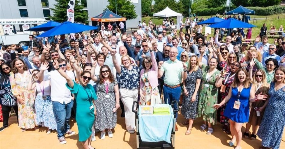 Group of people celebrate outside a research park in Surrey, UK