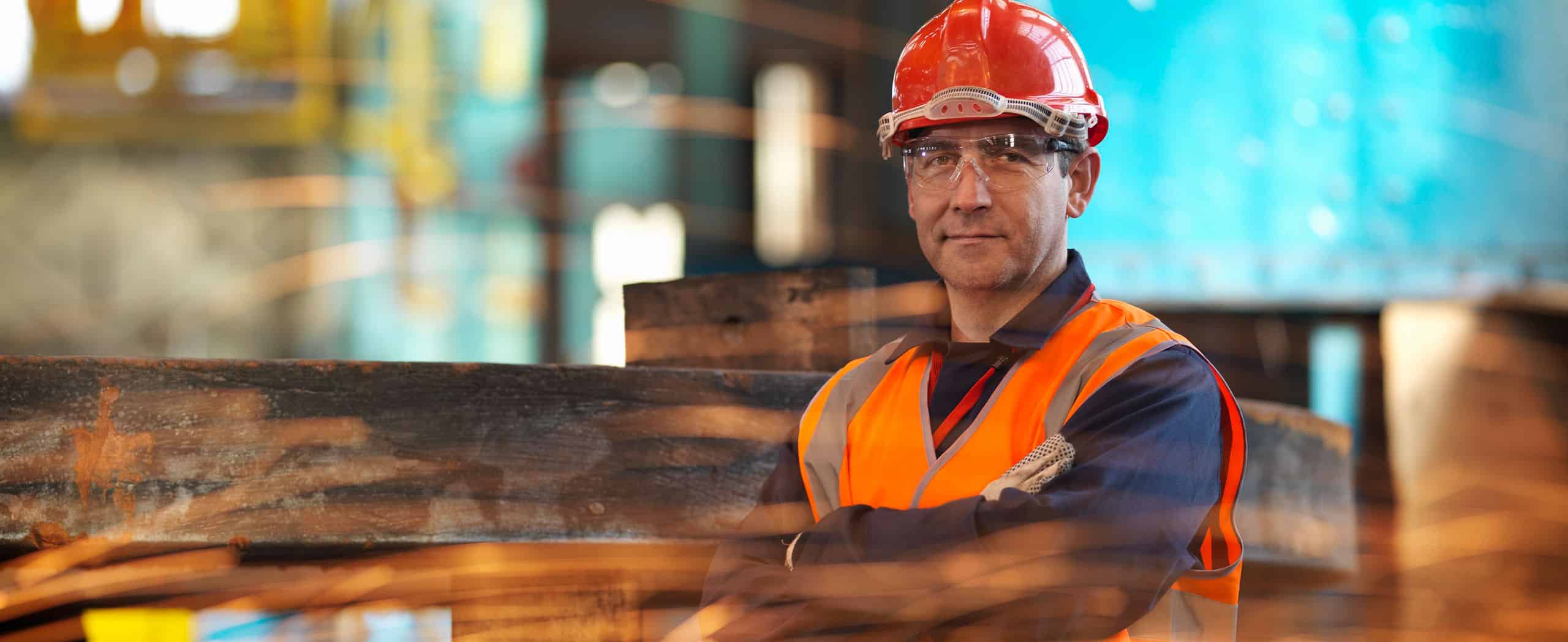 Man wearing a hard hat, high vis jacket and protective glasses
