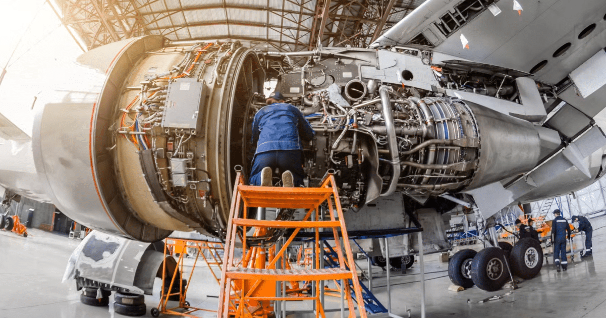 Close of a mechanic in a blue overall fixing an aeroplane (credit: 3TOP Aviation)