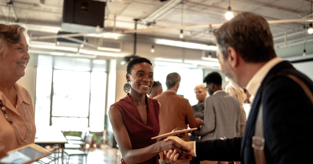 Business person at an event smiling and meeting other people. Business Surrey events.
