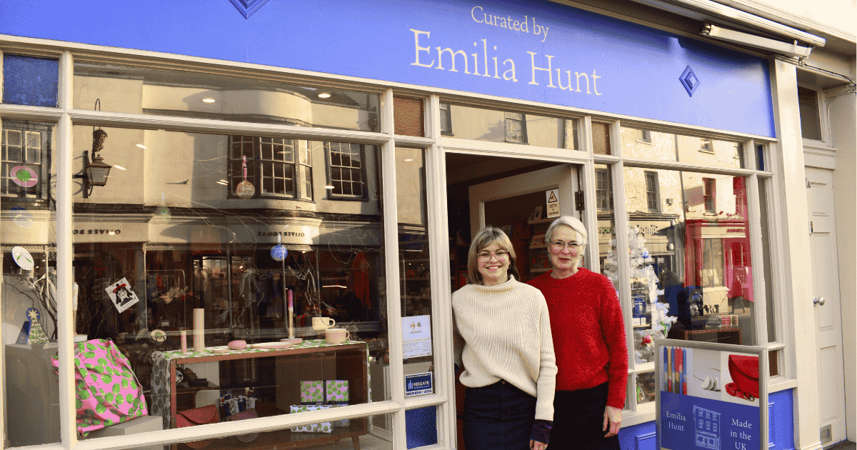 Emilia hunt stands with her mother in front of the shop window.