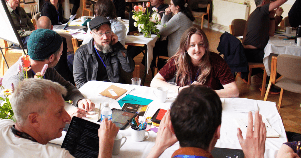 CoSTAR Emerge-AI - a group of delegates attending a workshop sit at a table working together | Business Surrey | AI accelerator