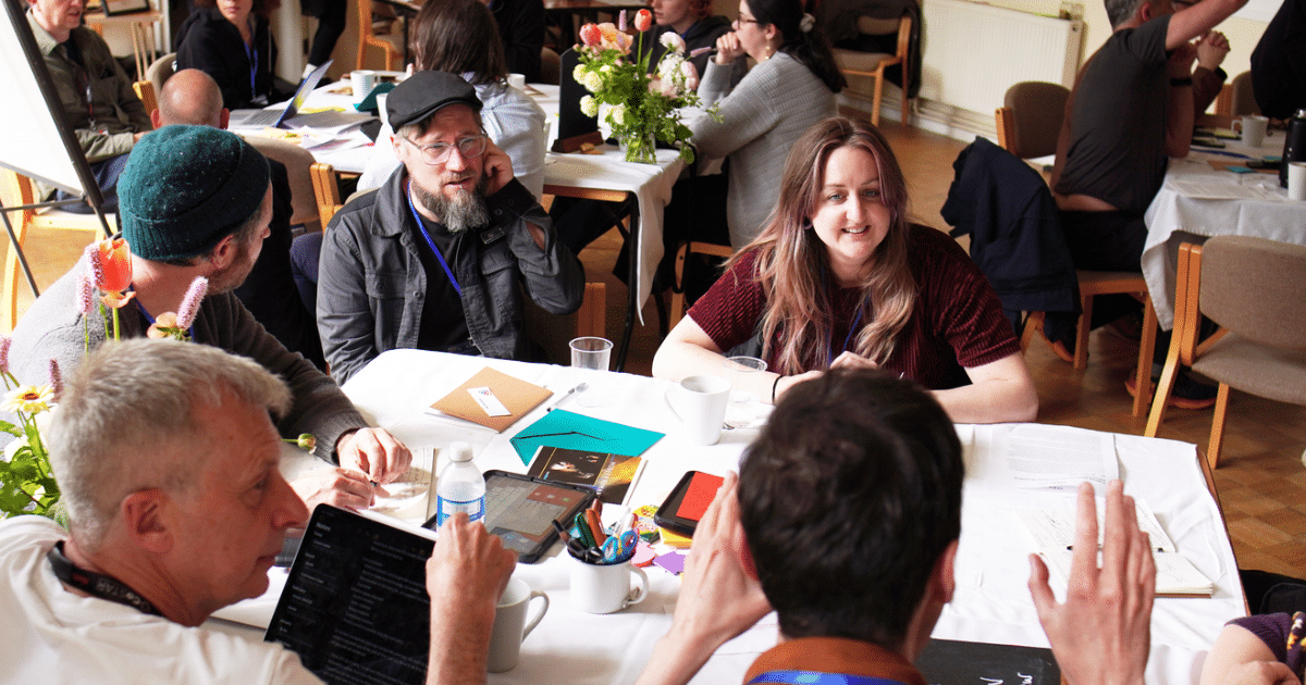 CoSTAR Emerge-AI - a group of delegates attending a workshop sit at a table working together | Business Surrey | AI accelerator