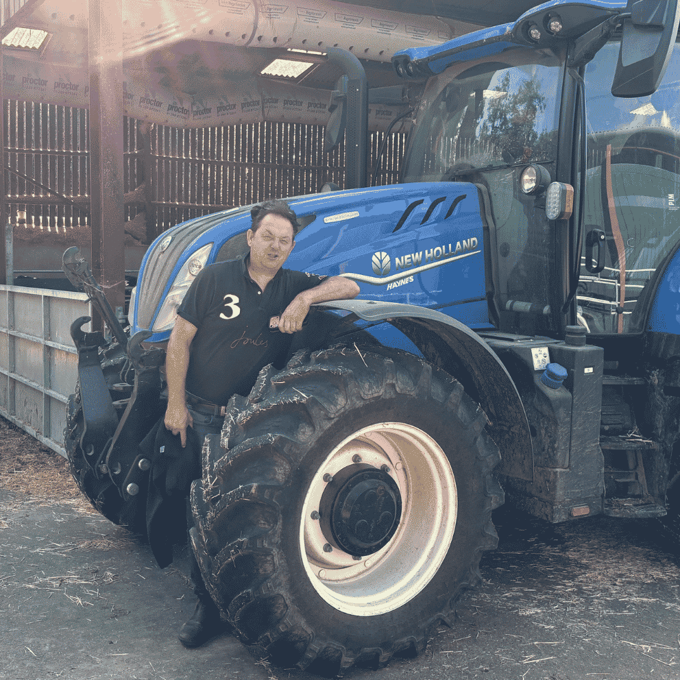 Farmer Hugh Broom of Sondes Place Farm stands next to his tractor | Surrey Farming Innovation Accelerator | Business Surrey